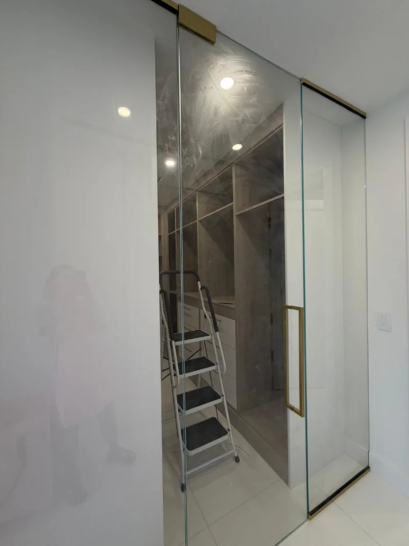 The same glass closet doors before cleaning — dusty and streaked